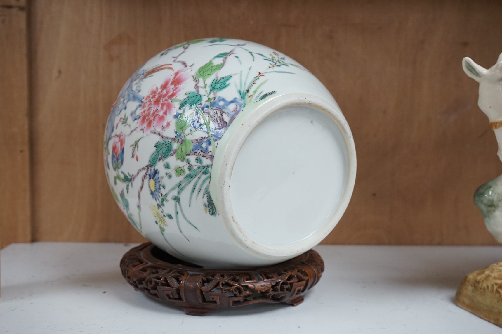 A late 19th century Chinese famille rose 'pheasant' jar lacking cover, with finely carved wooden stand, 21.5cm high including stand.